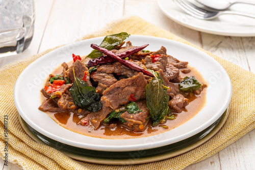 Spicy stir-fried beef slices with holy basil leaves, pad kra pao neua, a simple popular Thai food dish can be found throughout Thailand from street food carts to restaurants.
