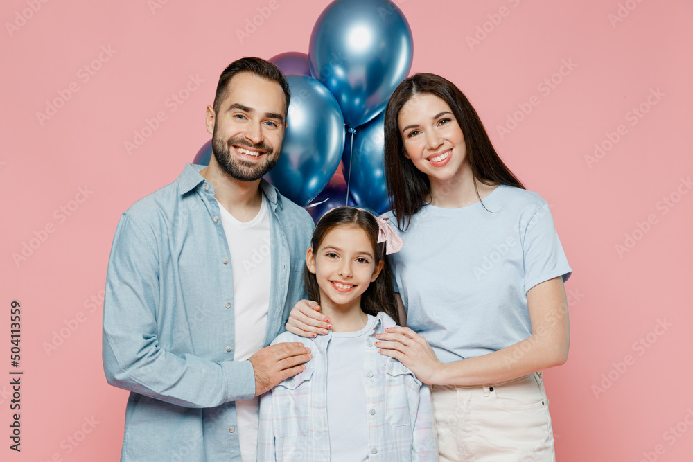 Young parents mom dad with child kid daughter teen girl in blue clothes celebrating birthday holiday party hold bunch colorful air inflated balloons hugging isolated on plain pastel pink background Young parents mom dad with child kid daughter teen girl in blue clothes celebrating birthday holiday party hold bunch colorful air inflated balloons hugging isolated on plain pastel pink background