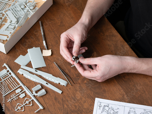 Model builder puts plastic fuselage pieces together. Stage of plastic model aircraft building