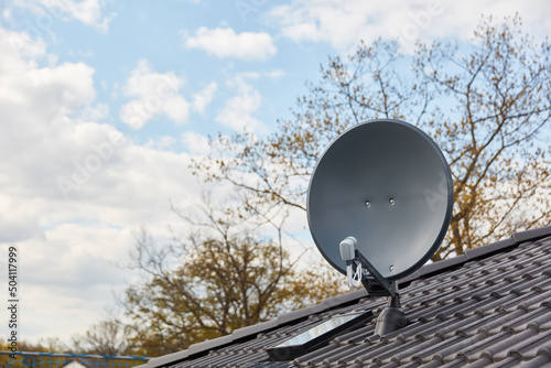 Satellitenschüssel auf Hausdach für Fernsehempfang