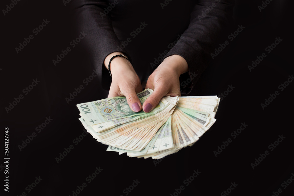 Kobieta wyciąga przed siebie ręce pełne pieniędzy, dużo pieniędzy w dłoni - obrazy, fototapety, plakaty 
