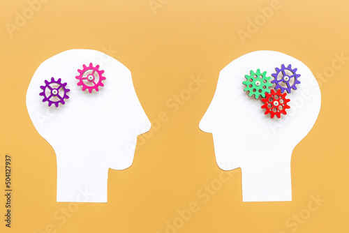 Brain work - gears on two paper human heads. Teamwork concept