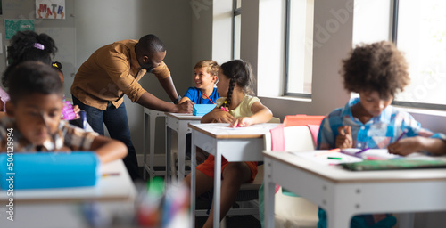 African american young male teacher teaching to multiracial students in classroom