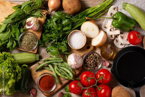 Assortment of vegetables, herbs and spices on wooden table. Top view. 
