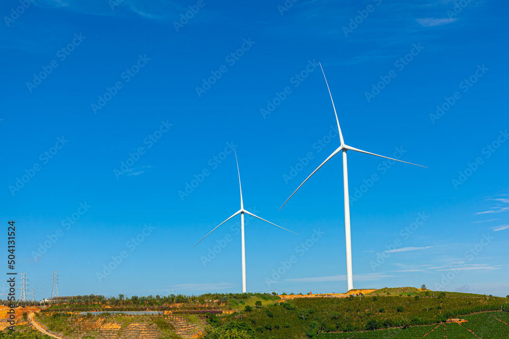 Renewable energy wind turbines windmill isolated on the beautiful blue sky and on the tea fields in Da Lat city, Lam Dong, Viet Nam Renewable energy wind turbines windmill isolated on the beautiful blue sky and on the tea fields in Da Lat city, Lam Dong, Viet Nam