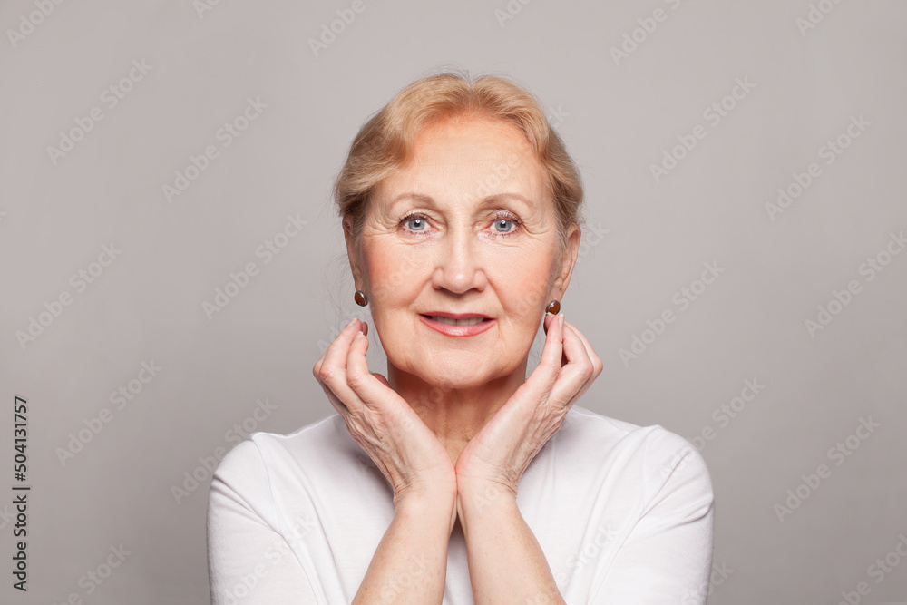 Beautiful senior woman holding her hands near her face and smiling Beautiful senior woman holding her hands near her face and smiling