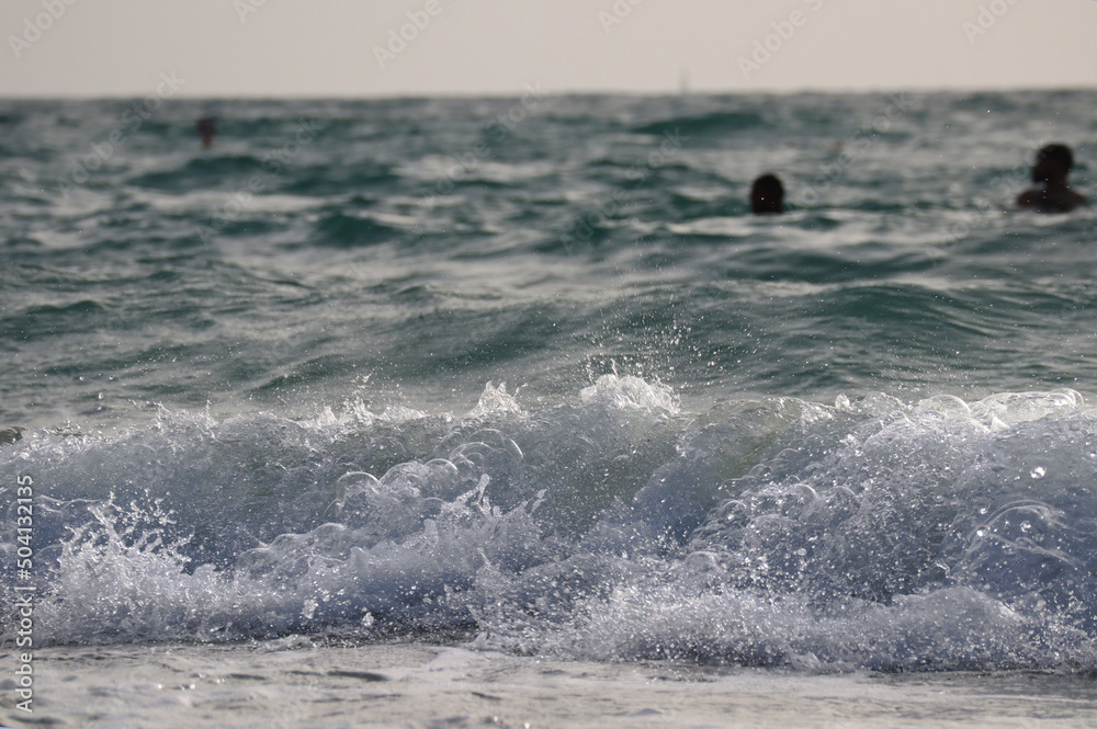 Close-up of sea waves on a sandy beach in Dubai, partially out of focus Close-up of sea waves on a sandy beach in Dubai, partially out of focus