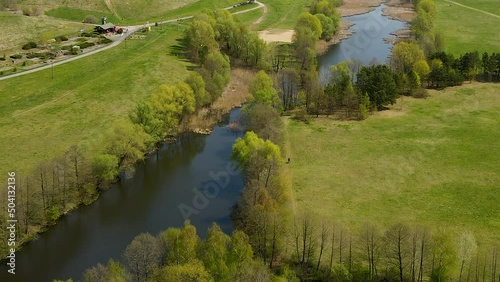 Lone Person Walks By The Rivershore Of Beautiful Greenery Lawn Of Myslecinek Nature Park In Poland. Aerial Shot photo