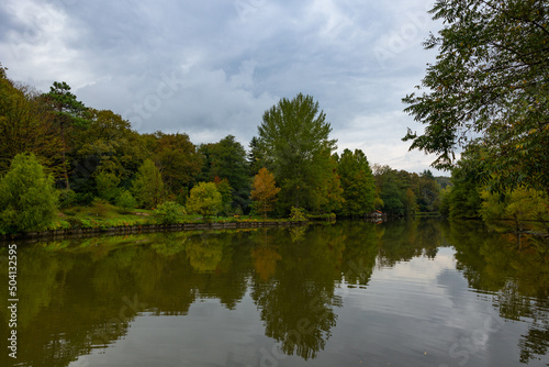 Pond or lake in the forest at autumn or fall with cloudy sky