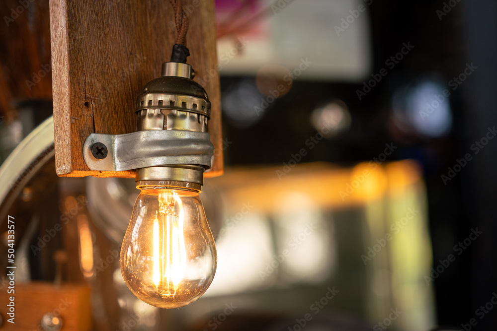 A classic style ceilling light bulb which is glowing in orange warm lighting shade. Interior object for room decoration. Close-up and selective focus. A classic style ceilling light bulb which is glowing in orange warm lighting shade. Interior object for room decoration. Close-up and selective focus.