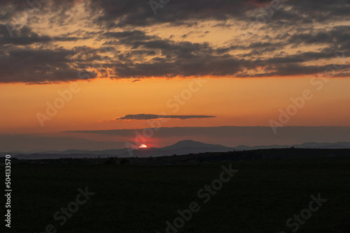 Beautiful sunset on rural landscape.Mountains in background.