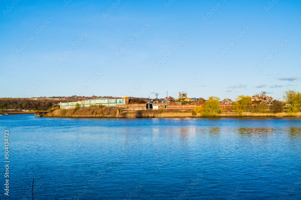 Blaydon UK: 2nd April 2022: Scrapyard with piles of scrap metal in a junkyard on the River Tyne in Newcastle during golden hour with clear blue skies