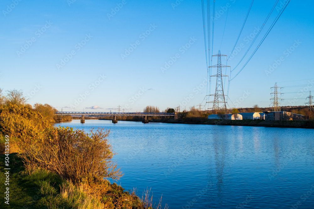 Pylon power lines against a deep blue sky crossing the River Tyne at Newburn (Newcastle upon Tyne)