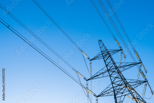 Pylon power lines against a deep blue sky