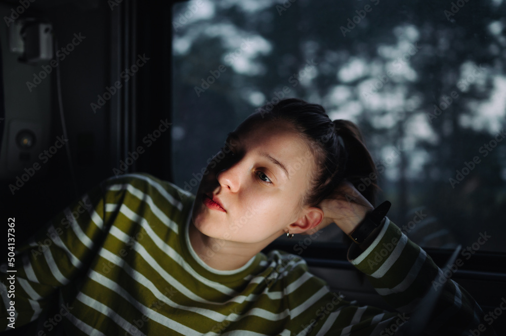 Portrait of a beautiful female tourist rides in a dinner train by the window and looks away. Portrait of a beautiful female tourist rides in a dinner train by the window and looks away.