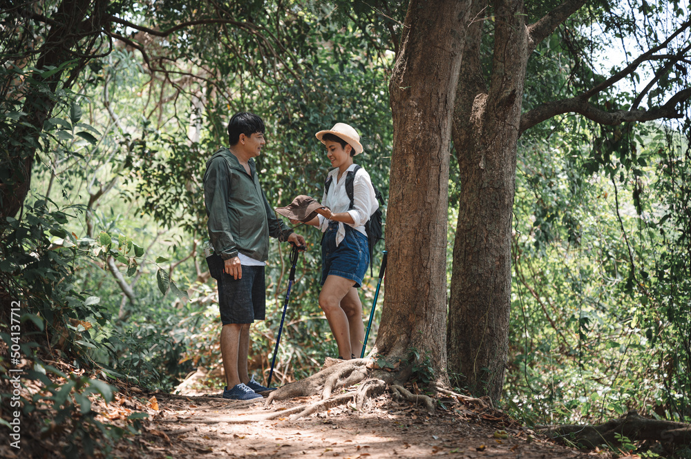 Happy asian adult couple trekking in the wood Happy asian adult couple trekking in the wood