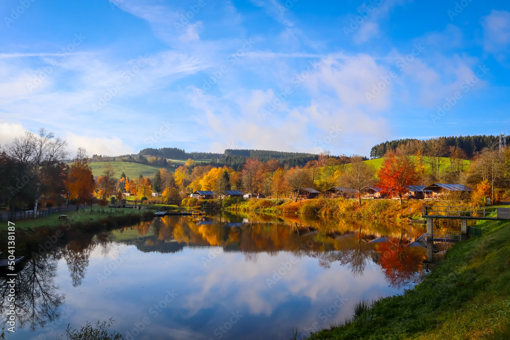 Reflection of nature and bright autumn colors in the lake Wirft, Stadtkyll, Germany Reflection of nature and bright autumn colors in the lake Wirft, Stadtkyll, Germany