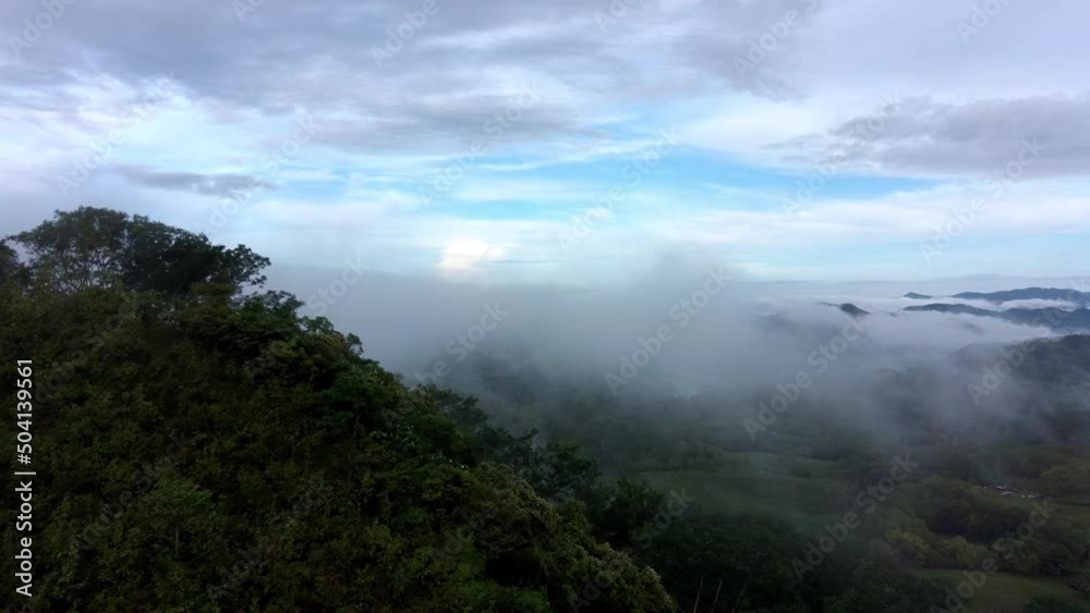 Drone flying over jungle hill in misty cloudscape. Amazon rainforest from above