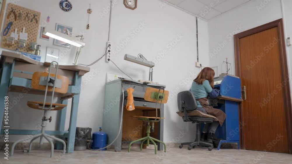 Portrait Of A Working Artisan Jeweler In Her Studio. Low Wide Angle