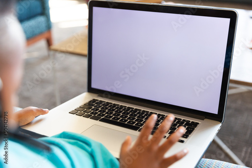 Close-up of african american elementary schoolboy using laptop while sitting in school