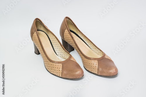 A pair of women's summer shoes with a heel in beige color isolated on a white background.