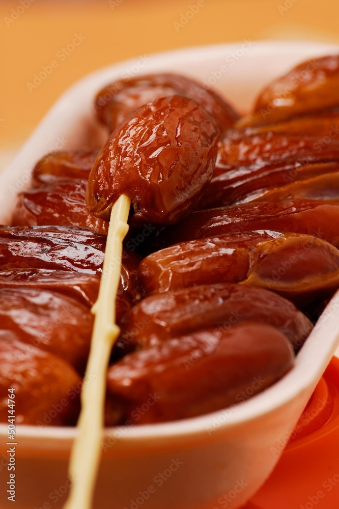Fresh Tunisian dates fruits on stick container.