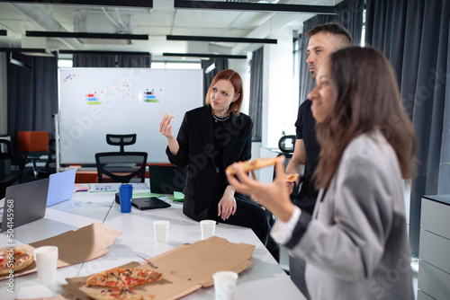 Colleagues eat pizza at the office during lunch