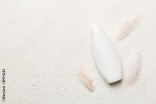 Set of skin care serums on pink pastel background with ostrich feathers. Spa cosmetic product, cream jar, branding mock up, top view with copy space photo