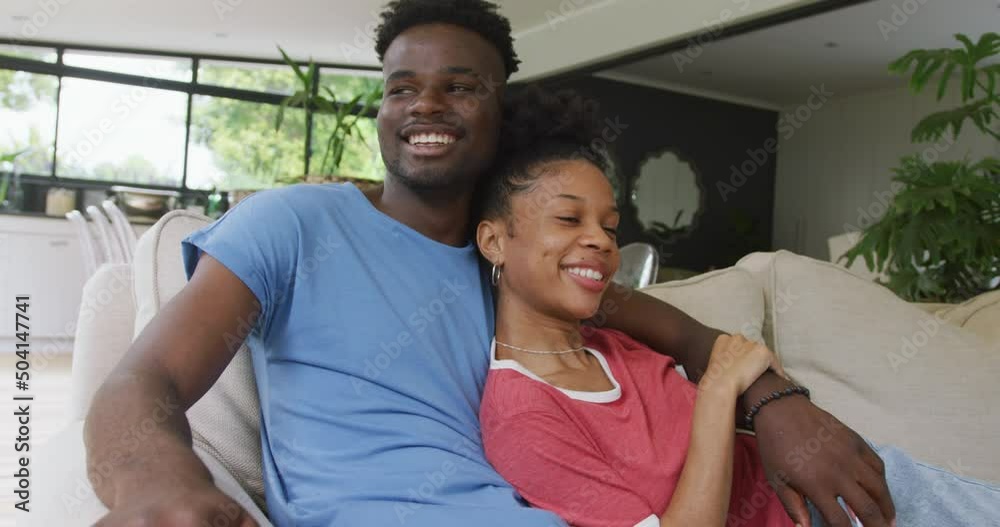 Video of happy african american couple sitting on sofa and embracing Video of happy african american couple sitting on sofa and embracing