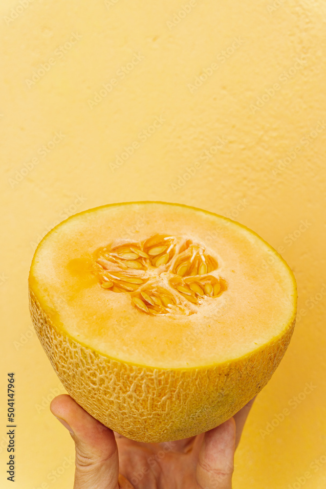 Melon kantalupa, tropikalny owoc na żółtym tle.