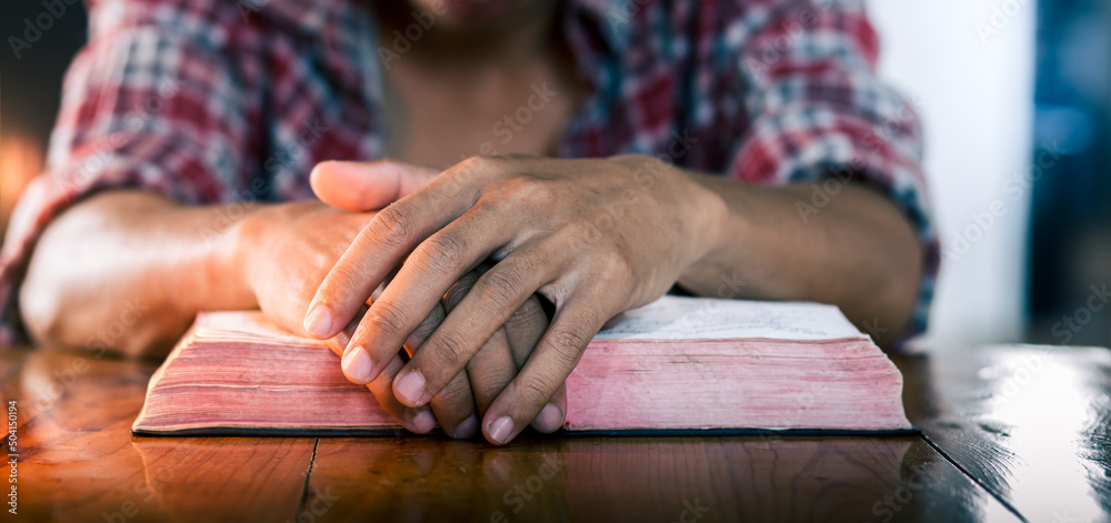 Obraz premium Hands praying of young christian man, put hands on the bible, Christian concept.