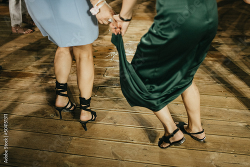 Two happy excited friends having fun at hen night club party event, dancing together.