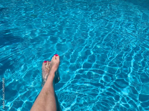 Female feet in swimming pool summer mood  © Yulia