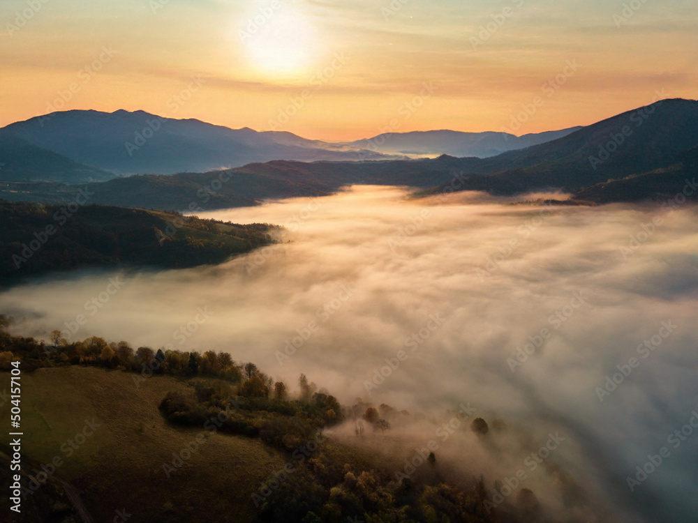 Beautiful mystery landscape with sunset sky and foggy forest between mountains hills. Carpathians mountains in Ukraine