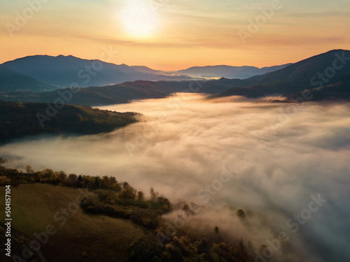 Beautiful mystery landscape with sunset sky and foggy forest between mountains hills. Carpathians mountains in Ukraine