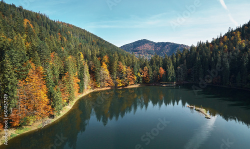 Beautiful landscape alpine lake Sinevir with pines woods around and mountaine. Blue sky in water surface