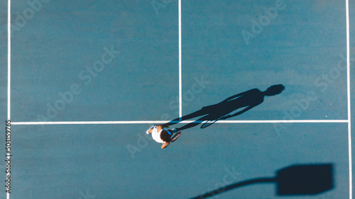 Directly above view of african american young female player playing on blue tennis court