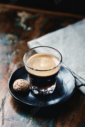 Coffee in glass cup on dark wooden background. Close up.