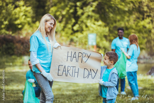 Happy Earth day! Diligent volunteers. Company of diligent volunteers working hard while cleaning up the trash left in forest. Diverse Group of People Picking Up Trash in The Park