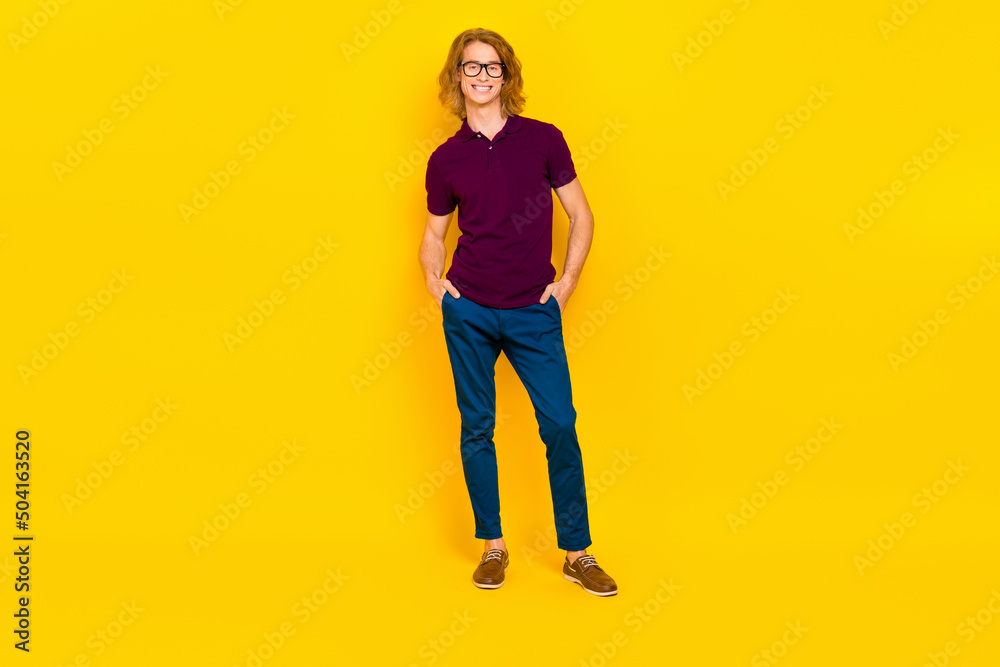 Full length portrait of cheerful glad person put arms pockets toothy smile isolated on yellow color background Full length portrait of cheerful glad person put arms pockets toothy smile isolated on yellow color background
