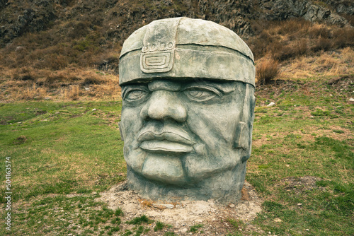 Olmec sculpture carved from stone. Mayan symbol - Big stone head statue in a nature photo