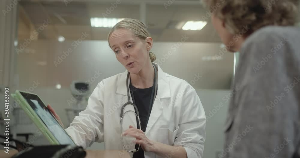 Doctor Discussing Medical X ray in Doctors Office with Senior Patient Doctor Discussing Medical X ray in Doctors Office with Senior Patient