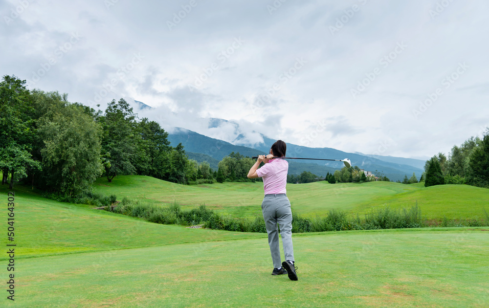 Woman golf player swinging golf club Woman golf player swinging golf club