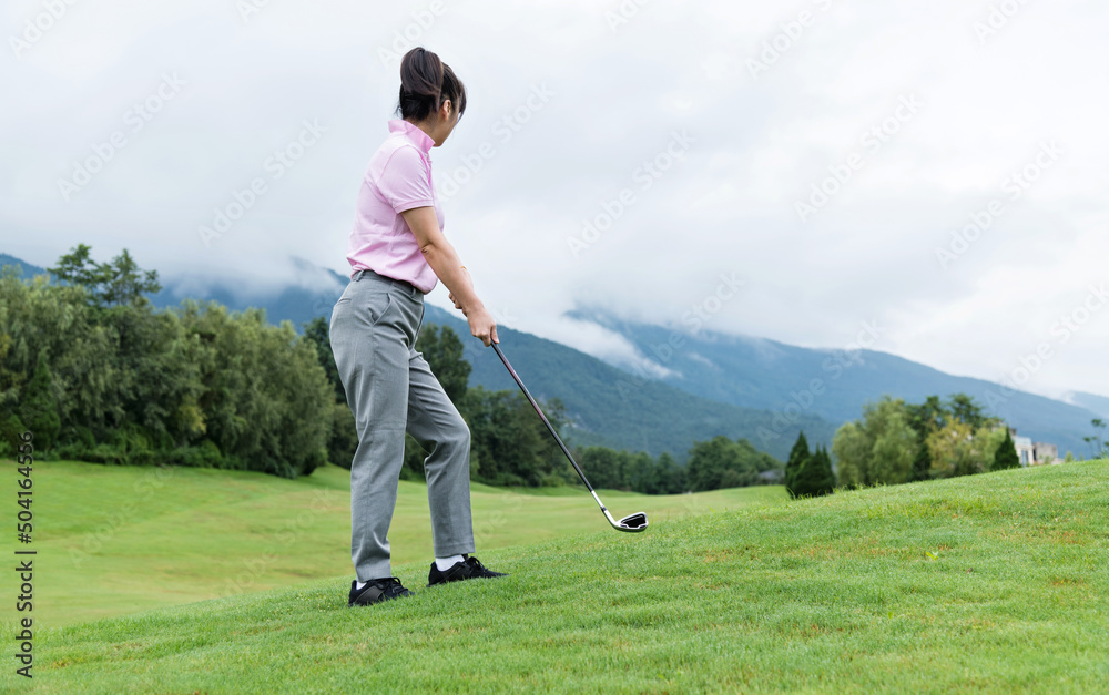 Woman golf player swinging golf club Woman golf player swinging golf club