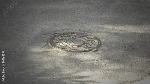 Top view of manhole sewer cover on asphalt. photo