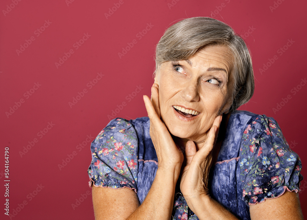 surprised senior woman isolated on red background surprised senior woman isolated on red background