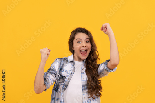 Fotografija glad teen kid in checkered shirt with long curly hair on yellow background