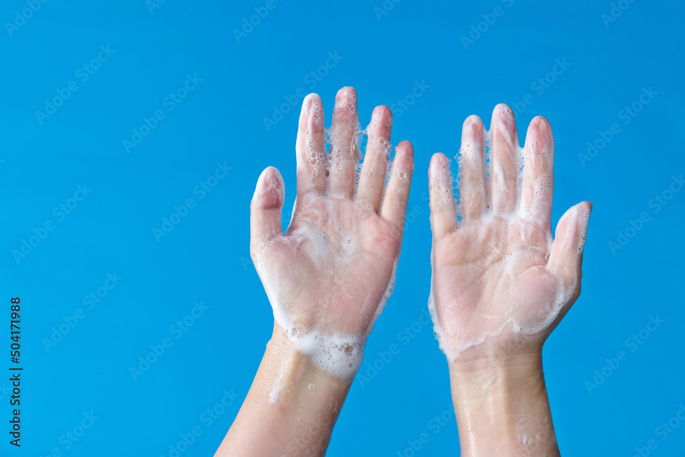 Woman washing hands on blue background Woman washing hands on blue background