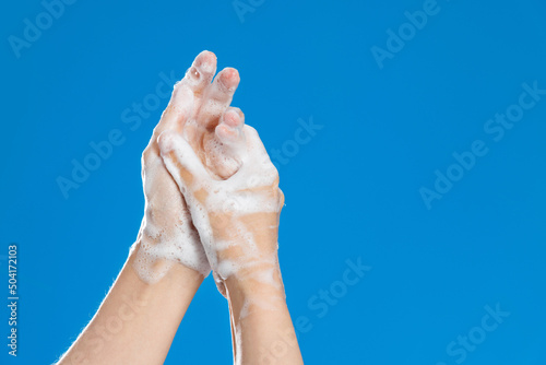 Woman rubbing palm on blue background