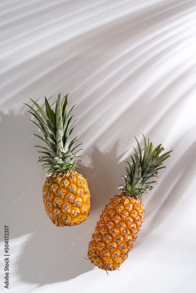 Juicy pineapple on a white background. A whole pineapple and a cut